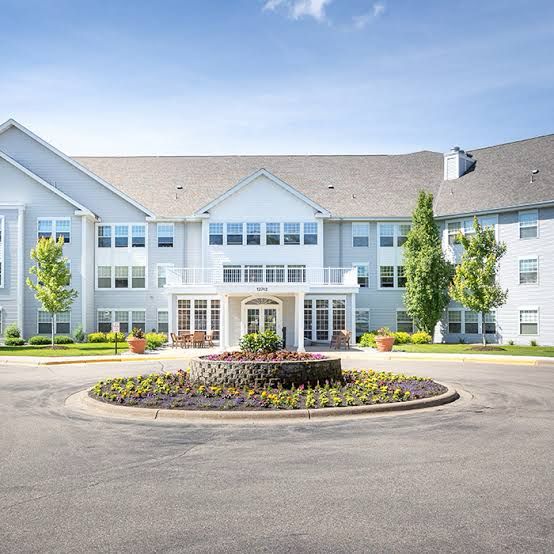 Senior living facility in Ferndale with accessible entrance, landscaped gardens, and seating area, emphasizing compassionate transportation services for medical appointments.
