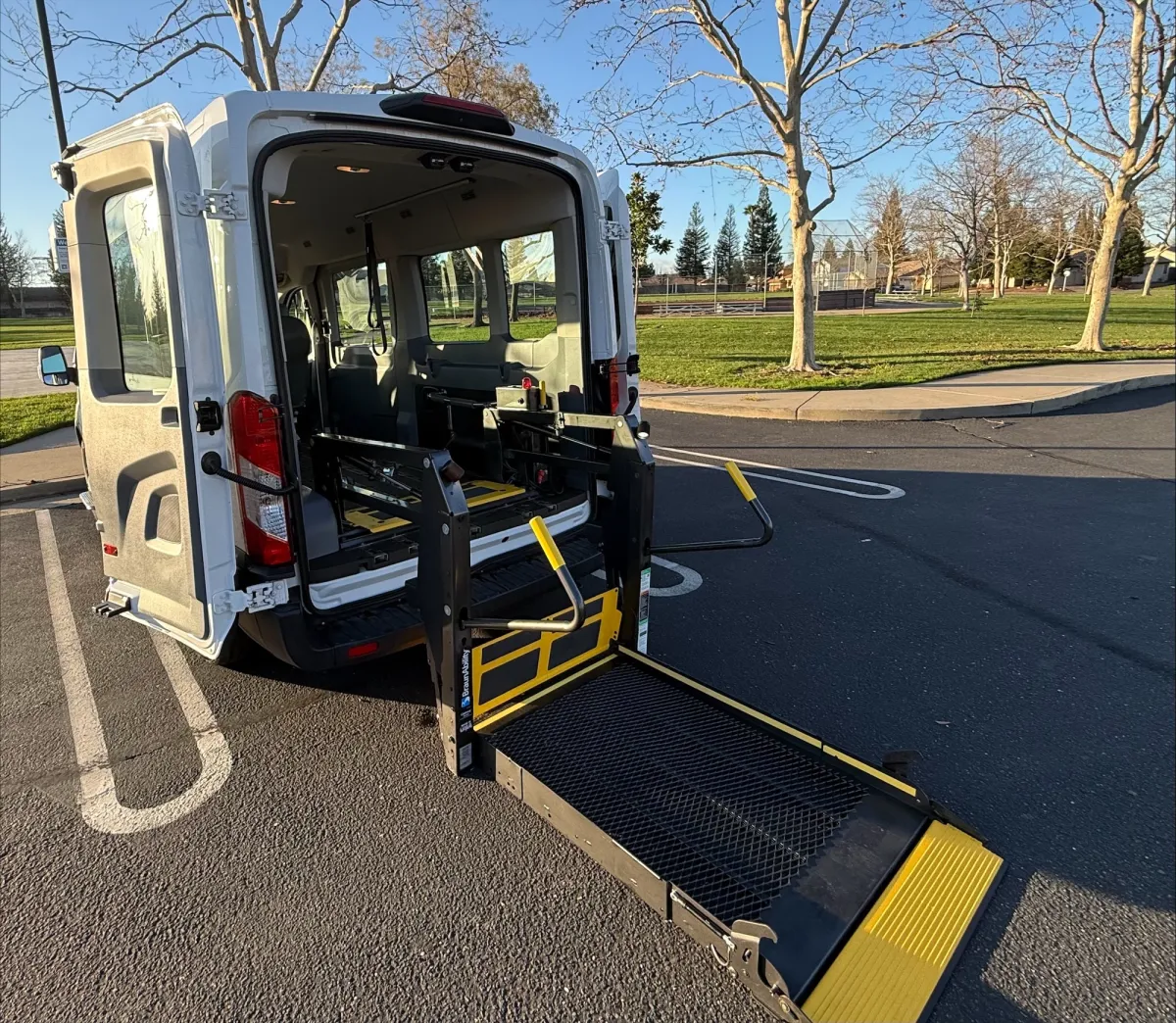 Wheelchair-accessible vehicle ramp extended, showcasing interior seating and safety features, emphasizing non-emergency medical transportation services by MBM Transportation.