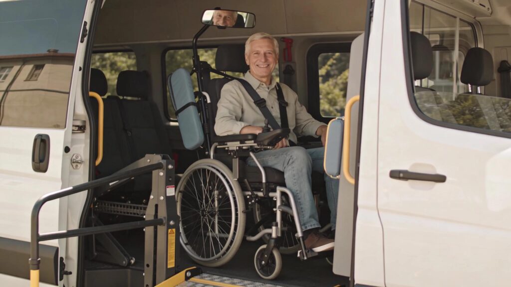 Smiling patient seated inside a wheelchair-accessible van with safety features